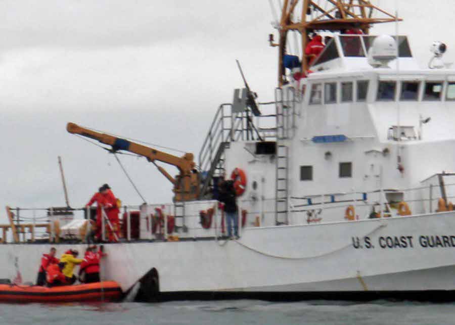 Szeba in yellow climbs aboard USCG Cutter Block Island